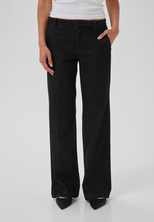 Zwarte wijde-denimbroek met een klassieke tailleband, zakken en een gladde textuur, gecombineerd met puntige zwarte hakken.