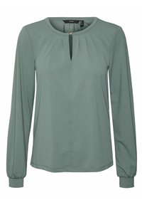 Blouse verte à manches longues avec un col rond, une ouverture clé à l'avant, des détails plissés et des poignets élastiqués. Texture de tissu lisse.