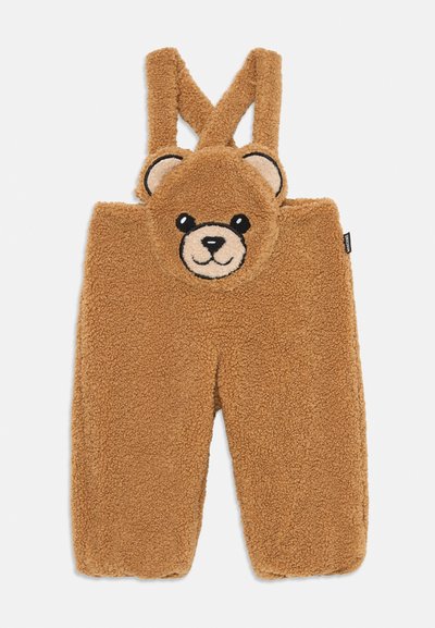 Bruine fleece overalls met een teddybeertjesgezicht op de voorkant, met dikke schouderbanden en een zachte, textuurrijke afwerking.