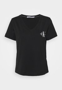 Czarny T-shirt z krótkim rękawem w serek, z białym logo Calvin Klein Jeans na lewej piersi, prezentowany na białym tle.