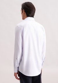 Camicia a maniche lunghe a righe blu chiaro con un grande colletto, polsini con bottone e orlo curvo; realizzata in un tessuto liscio e leggero.