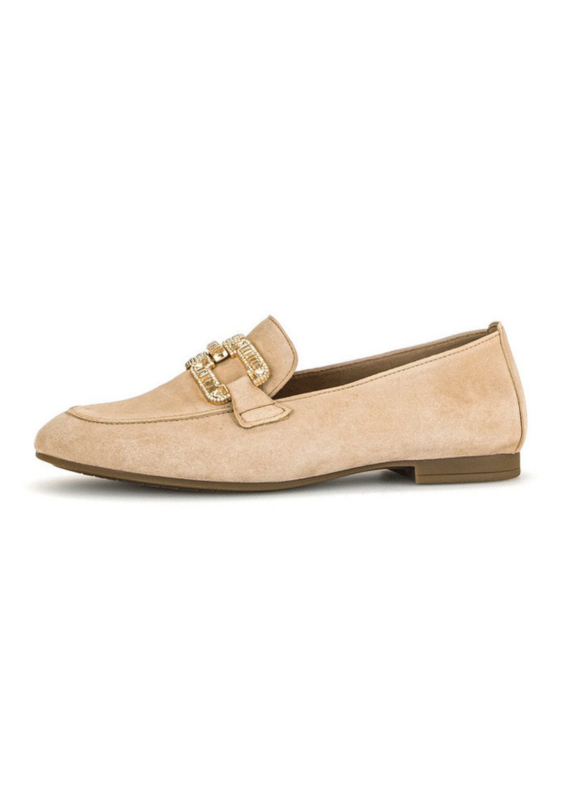 Mocassins en daim beige avec une semelle plate, dotés d'une boucle décorative en or et d'un design couturé sur le devant.