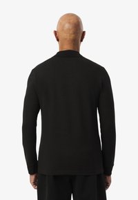 Schwarz langärmliges Hemd mit Polo-Kragen, aus glattem Stoff. Verfügt über eine lockere Passform und dezente Nähte an den Ärmeln und dem Saum.