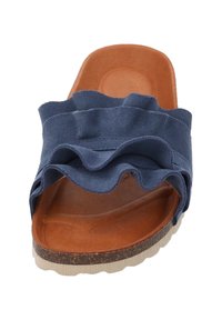 Mørkeblå ruskinds slide sandal med et bølget ruffle-design, lysebrunt polstret fodseng og en lys, tekstureret gummisål.