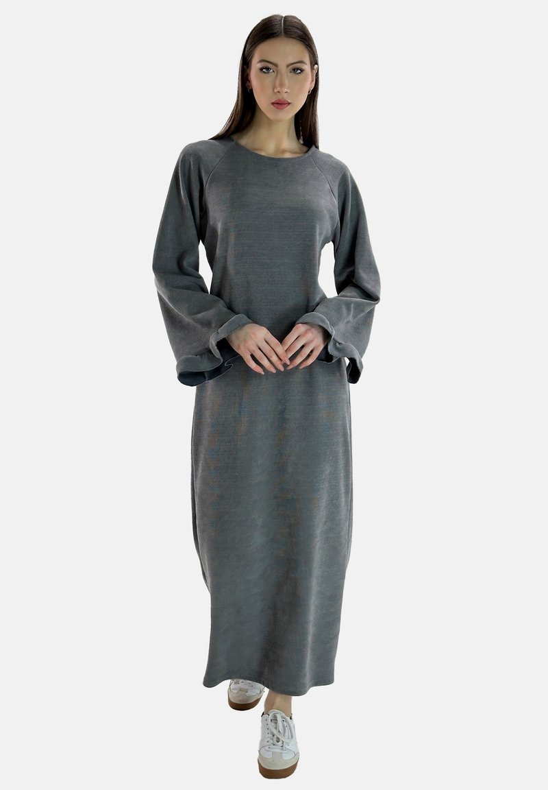 Vestido gris de manga larga hecho de un tejido suave, con escote redondo y mangas acampanadas. Combinado con zapatillas blancas y un corte holgado.