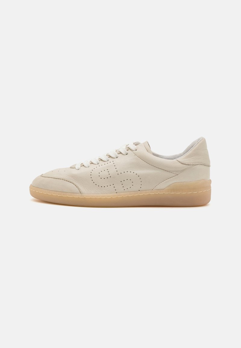 Beige lærstøvlett med rund tå, perforert design og lys beige gummisåle. Den har hvite snørebånd og en polstret krage.