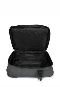 Bolsa de tela gris con un interior negro, cierre con cremallera y correas internas. Textura suave y forma rectangular. Abierta y sin llenar.