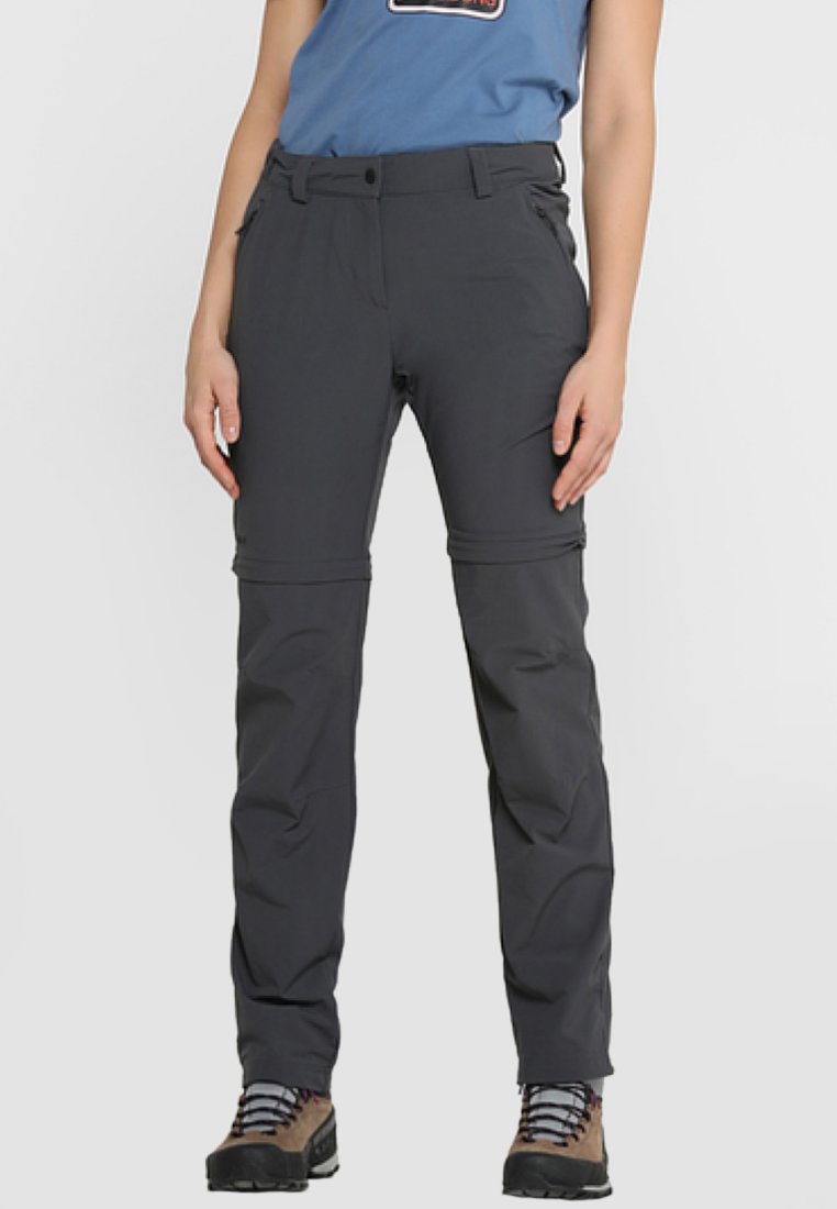 Pantalones exteriores grises con piernas con cremallera para convertir en pantalones cortos, con un diseño sencillo y un bolsillo en el lateral, combinados con botas de senderismo.