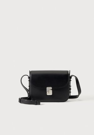 Bolso bandolera de cuero negro con solapa, cierre plateado y correa de hombro ajustable, sobre un fondo liso.