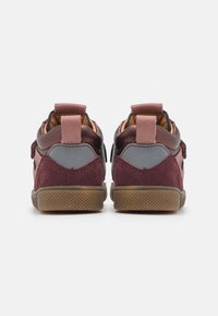 Baskets bordeaux et grises en matériaux daim et cuir, avec une semelle en caoutchouc texturée et des accents roses. Système de fermeture par bande Velcro.