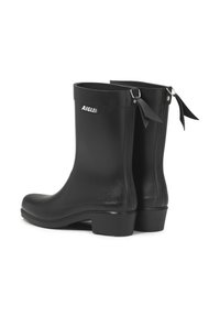 Black rubber rain boots with a glossy finish, square heel, textured surface, and bow accents at the back. Aigle logo on the side.