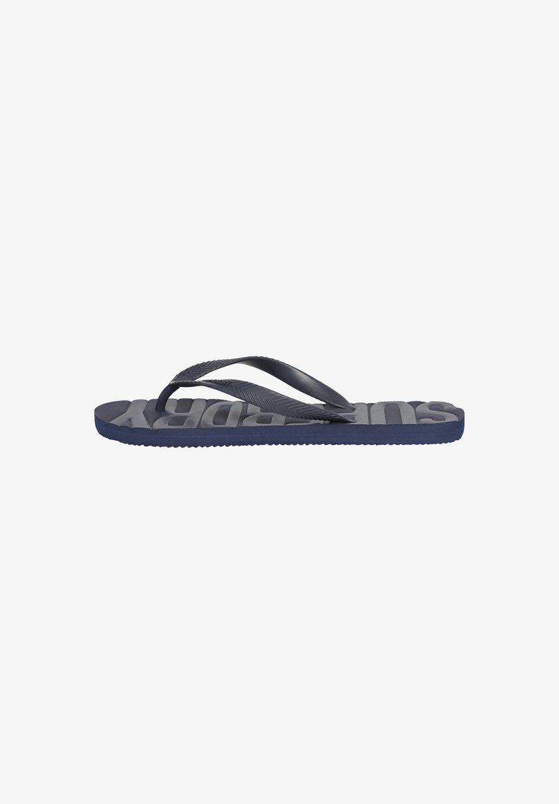 Tongs bleu marine avec semelle en caoutchouc texturé et fines sangles. Présente un grand logo en relief sur le lit de pied et un motif en chevrons sur les sangles.