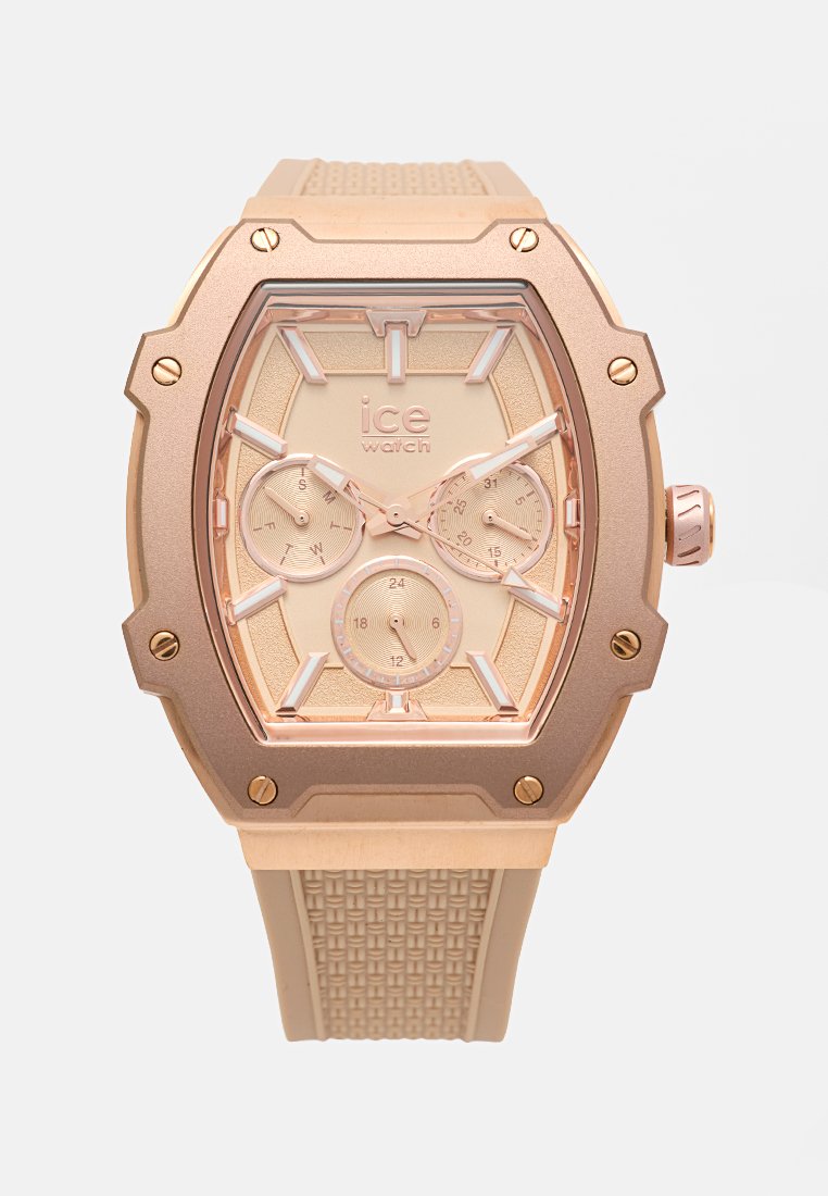 Roségoldene Uhr mit texturiertem Gummiarmband, achteckigem Gehäuse, drei kleineren Zifferblättern und klaren Stundenmarkierungen. Überwiegend glänzende Oberfläche.