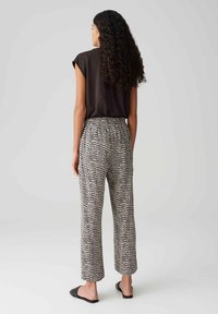 Haut noir à manches courtes assorti à un pantalon taille haute à motifs en noir et blanc. Tissu doux et respirant avec une coupe décontractée.