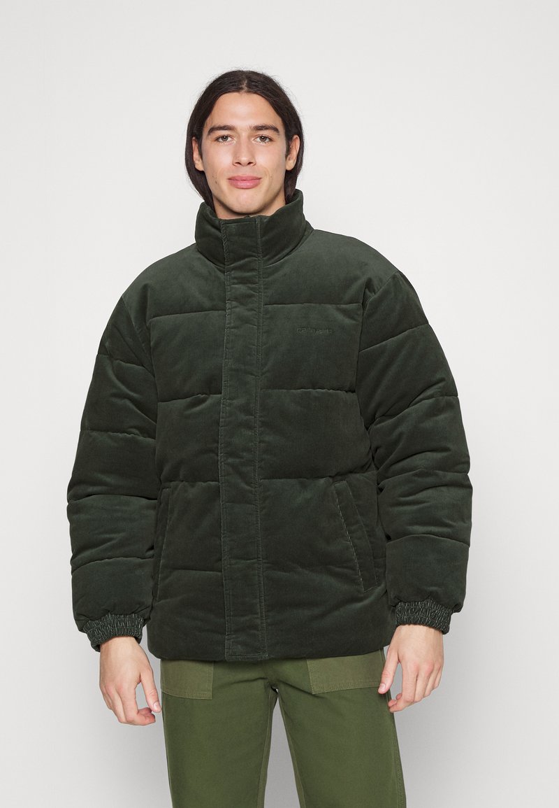 Dark green padded jacket with high collar, elastic cuffs, and side pockets. Made from soft material with a quilted texture.
