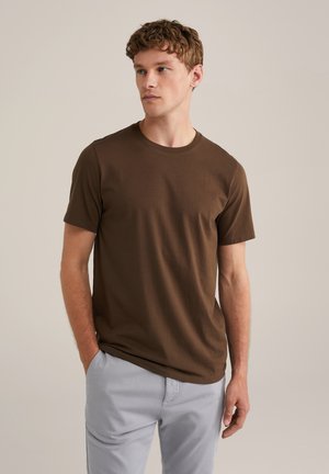 Brown short-sleeve t-shirt made from soft fabric, features a crew neckline and a relaxed fit, paired with light gray pants.