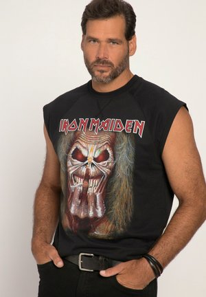 Schwarzes ärmelloses T-Shirt mit einem grafischen Motiv eines Schädels mit langen Haaren, roten Augen und aufwendigen Details. Der Text "IRON MAIDEN" ist gut sichtbar platziert.