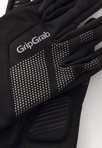 Juodi pirštinės su tekstūruotu sukibimu ir sidabriniais taškeliais, pagamintos iš tamprios medžiagos, ant kurių aiškiai matomas "GripGrab" logotipas.