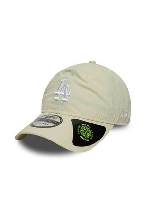 Casquette de baseball beige avec logo "LA" brodé en blanc, bandeau ajustable et visière noire avec branding New Era vert et noir sur le côté.
