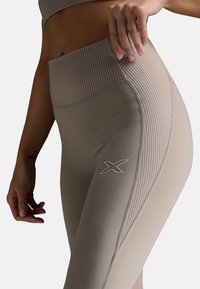 Beige, hochtaillierte Leggings mit gerippter Textur und elastischem Bund. Mit seitlichem Logo und taillierter Passform für Flexibilität.