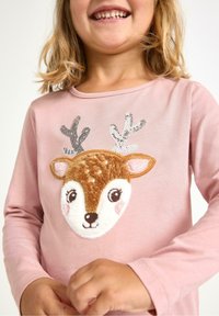 Lys pink langærmet skjorte med en hindapplikation, der har broderede detaljer, blød tekstur og glitrende pailletantler.
