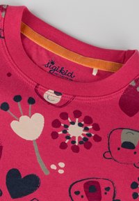 Rotes Baumwoll-T-Shirt mit Cartoon-Tier- und Blumenmustern in Pink, Schwarz und Creme; runder Ausschnitt mit einem orangen inneren Besatz.