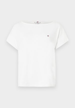 T-shirt en coton blanc avec un col bateau et des manches courtes. Présente un petit logo brodé en rouge, blanc et bleu sur la poitrine gauche.