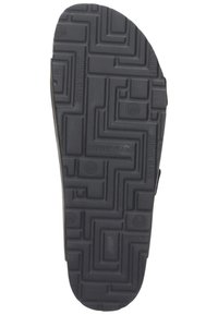 Black rubber shoe sole with a textured pattern featuring spirals and geometric shapes. Brand name "Brinkmann" embossed on the surface.