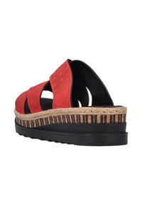 Sandale rouge avec trois larges brides, une plateforme en jute tressé et une semelle en caoutchouc noir. Haute en texture avec des perforations pour la ventilation.