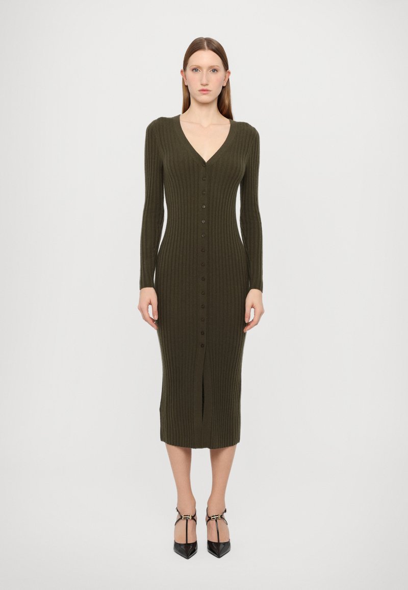 Rochie midi côtelată de culoare verde închis, cu decolteu în V, mâneci lungi, nasturi frontali și fante la coapsă. Textură netedă, siluetă ajustată.