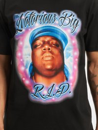 Melnas T-krekls ar grafisku attēlu, kurā redzams vīrietis zilā bandanā, ko ieskauj rozā un baltas mākoņi, ar tekstu "The Notorious Big" un "R.I.P."
