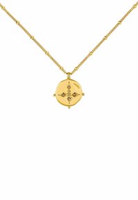 Collar de oro con un colgante ovalado que presenta una superficie texturizada y motivos decorativos de ojos, descansando sobre una delicada cadena con acentos de cuentas.
