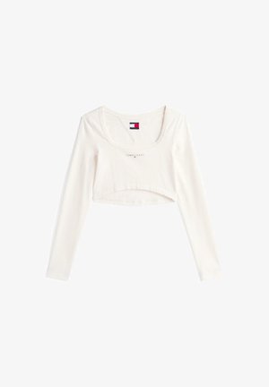 Haut court à manches longues en coton écru avec un col arrondi, arborant le logo "TOMMY JEANS" en gris clair sur la poitrine.