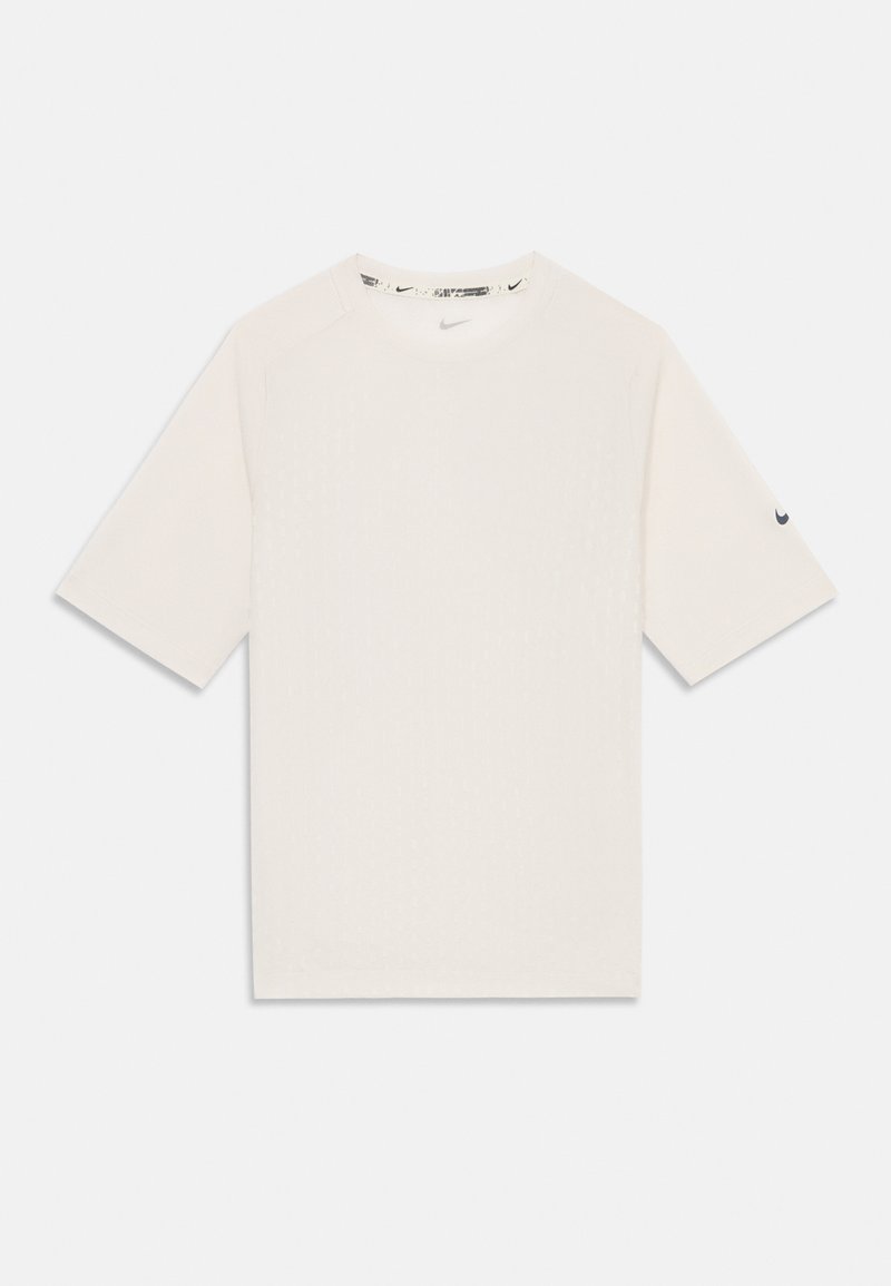 Camiseta blanca de manga corta hecha de tejido suave, con un patrón texturizado y un logo negro de Nike en la manga izquierda. Escote redondo.