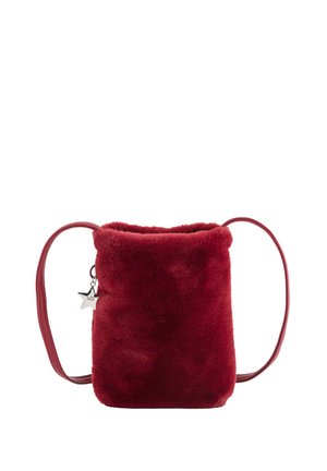 Bolso de piel sintética roja con textura suave, forma rectangular y una correa corta de cuero. Cuenta con un colgante de estrella plateada.