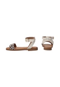 Flache Sandalen mit einem weißen Lederknöchelriemen und einem Leopardenmuster. Sie haben eine braune Sohle und ein weiches Innenfutter für zusätzlichen Komfort.
