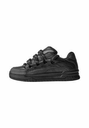Black sneakers with a smooth leather upper, textured accents, and round black and white laces. Thick rubber sole with a patterned tread.