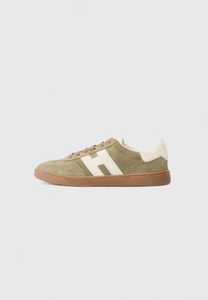 Beige suede sneaker with brown sole, lace-up front, and large white "H" logo on the side, displayed on a white background.