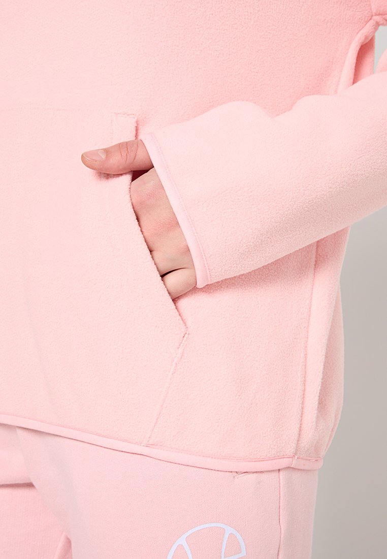 Pull-over en polaire rose clair avec une poche kangourou et des poignets ajustés. Il présente une texture douce et un design simple sans embellissements.
