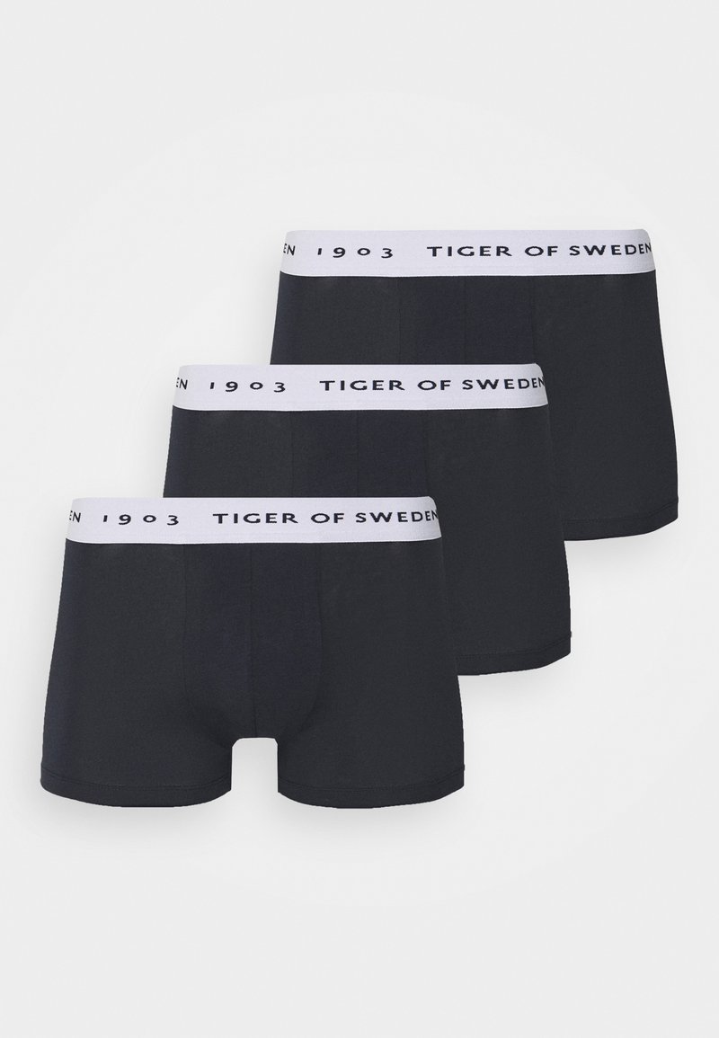 Boxer shorts pretos feitos de tecido suave, com uma cinta elástica branca com a inscrição "TIGER OF SWEDEN". Três pares estão expostos.