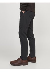 Svarta chinos med smal passform, med sidofickor, mjukt bomullsmaterial och bruna läderskor med texturerad sula.