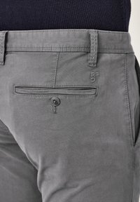 Grau Chinos aus einem Baumwollmischgewebe, mit einer geknöpften Gesäßtasche und einem dezenten Logo-Acccent in der Nähe des Bunds.