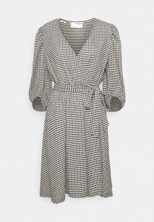 Vestido cruzado de cuadros en blanco y negro con mangas hasta el codo, cintura con cinturón y escote en v. Tejido ligero con textura suave.