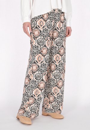 Weite Hose aus einem gemusterten Stoff mit hexagonalen Formen in Schwarz, Pfirsich und Creme. Weiche Textur mit floralen Akzenten.