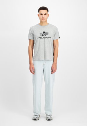 Gray cotton t-shirt with black logo print, paired with light blue denim jeans and gray sneakers. Simple, relaxed fit design.
