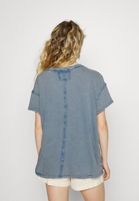 Blå oversized t-shirt med synliga sömmar, korta ärmar och rundad halsringning. Tillverkad av mjukt, strukturerat tyg.