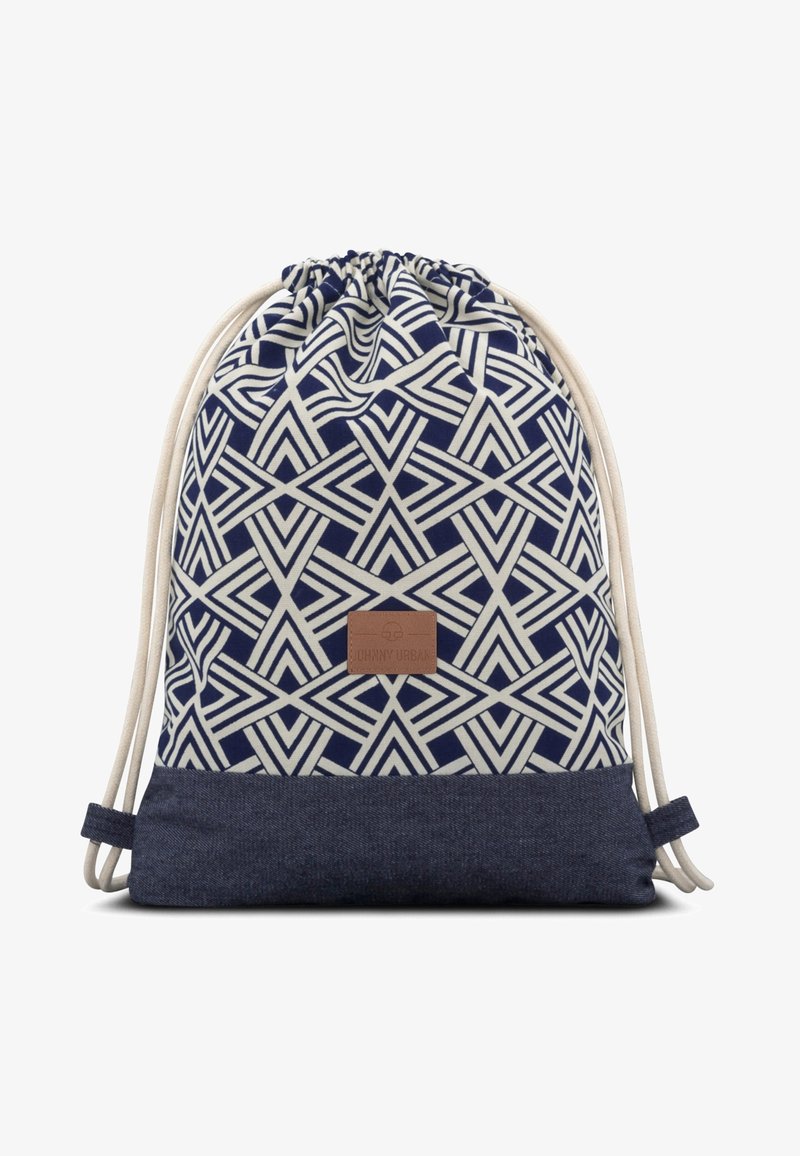 Navy drawstring backpack features a geometric cream pattern, denim bottom, natural-colored cords, and a tan logo patch.