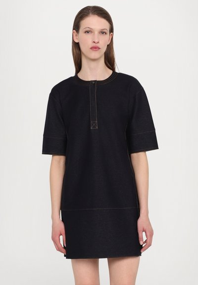 Mustat farkkukleidit lyhyillä hihoilla, pyöreällä kaula-aukolla, etupainikkeilla ja kontrastivärisellä oranssilla ompelella. Suora, vartalonmyötäinen malli vyötärölle.