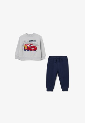 Sudadera gris claro con un diseño de Lightning McQueen en rojo y amarillo, combinada con pantalones jogger azul marino con cintura ajustable.