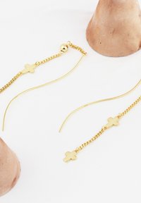 Orecchini in tono dorato con design a catena, con due piccole decorazioni a croce, una su un anello e una su un filo dritto. Finitura liscia e lucida.